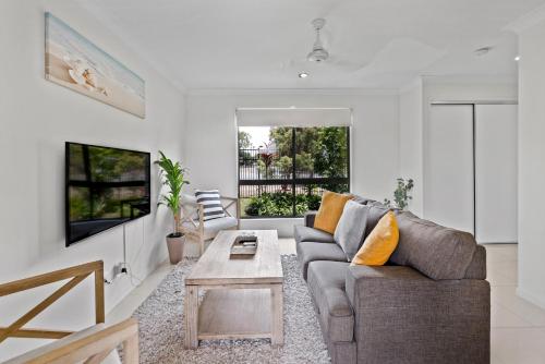 a living room with a couch and a coffee table at Beach Breeze Holiday House in Mackay