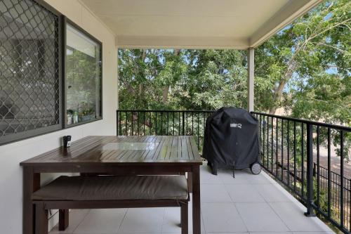 a wooden table and bench on a balcony at Beach Breeze Holiday House in Mackay