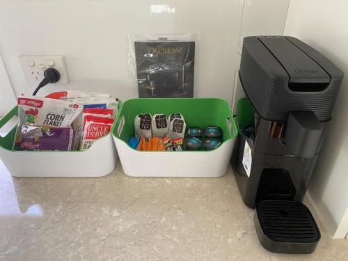 Una cafetera junto a dos recipientes y una impresora. en Allawah at Wamberal, en Wamberal