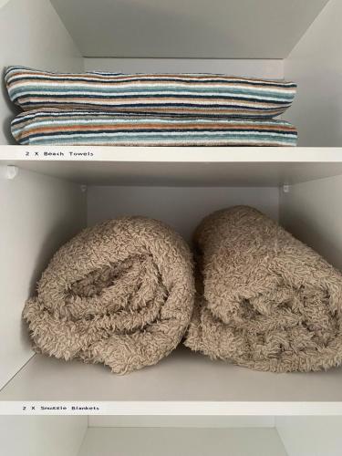 two towels sitting on a shelf in a closet at Allawah at Wamberal in Wamberal