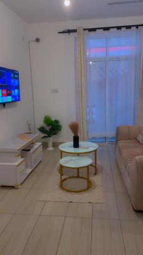 a living room with a table and a couch at Modern Smart Apartment with Easy Access in Mtwapa