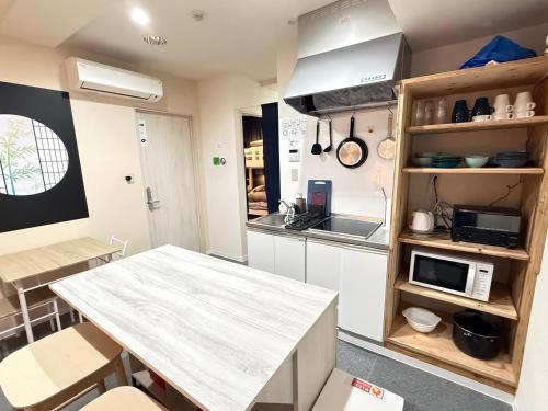 a kitchen with a table and a counter top at Wabi Sabi Hostel Shinjuku West in Tokyo