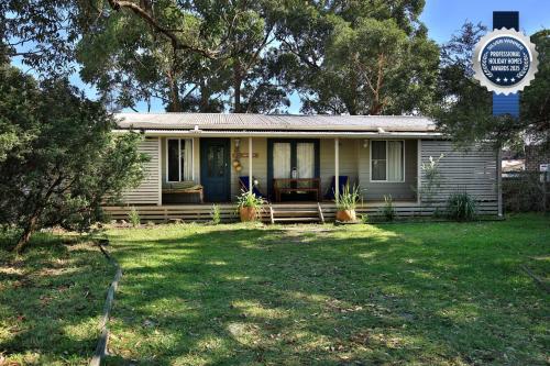 a house with a sign in front of it at Innisfree I Pet Friendly I 2 Mins to Beach in Callala Beach
