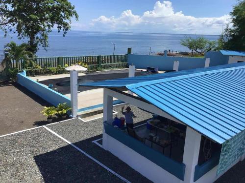 un toit bleu sur une maison avec l'océan en arrière-plan dans l'établissement Solaya Cove Private Resort, à Bansud