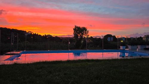 a swimming pool with a sunset in the background at Villa Malvasio Pool and Jacuzzi Room Sassari in Sassari