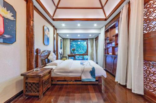 a bedroom with a bed and a table and a window at Mengtianhu Inn in Lijiang