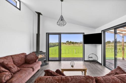 a living room with a couch and a fireplace at Pakawau Inlet House in Pakawau