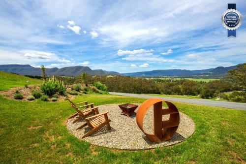 a park with a bench and a wooden sculpture at Stella at Kangaroo Valley - Amazing Views - Fire Pit in Barrengarry