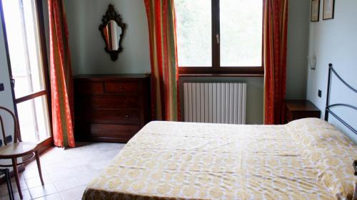 1 dormitorio con cama, mesa y ventanas en Le Fontane, en Urbino