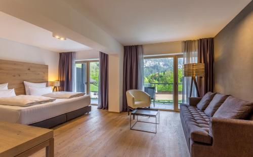 Habitación de hotel con cama y sofá en Das Graseck - mountain hideaway & health care en Garmisch-Partenkirchen