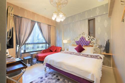 Un dormitorio con una cama grande y una silla roja. en Najima B&B, en Jian