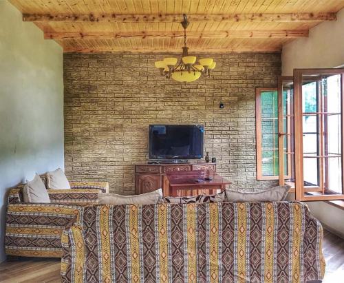 a living room with a couch and a tv at Zeyvə Farm House 