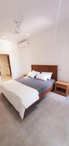 een slaapkamer met een groot bed in een kamer bij Les Vues de Monte Carlos in Tamarin