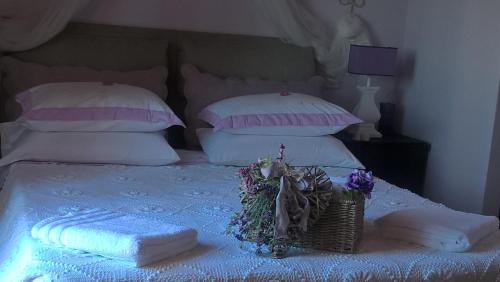a bed with towels and a basket of flowers on it at Piccolo Relais Galletto di Marzo Spa e relax solo per due in Paciano