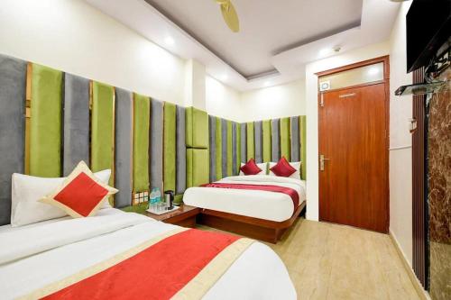 two beds in a room with green and red at Hotel Prem Dx 2 Min Walk From New Delhi Railway Station in New Delhi