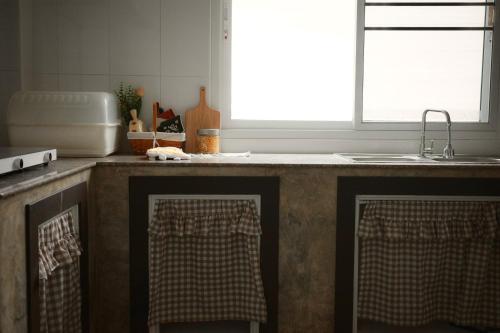 a kitchen with a sink and a counter with two towels at Browny house - Doi Suthep View in Chiang Mai