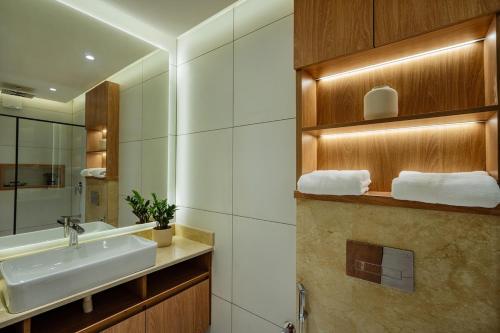 a bathroom with a sink and a mirror at Royale Suites - 3 BHK Serviced Apartment in Kadayirippu