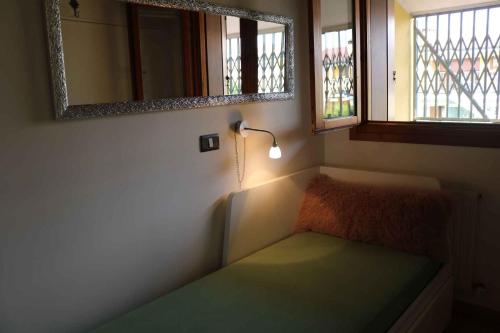 コラ・ディ・ラツィーゼにあるApartment in Colà di Lazise - Gardasee 54694のランプと2つの窓が付いたベッドのある小さな部屋