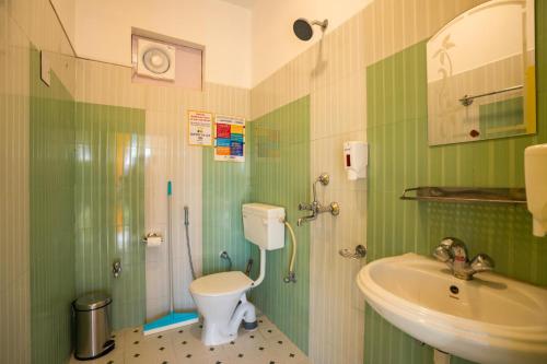 uma casa de banho verde com um WC e um lavatório em goSTOPS Bir, Landing Site em Bir