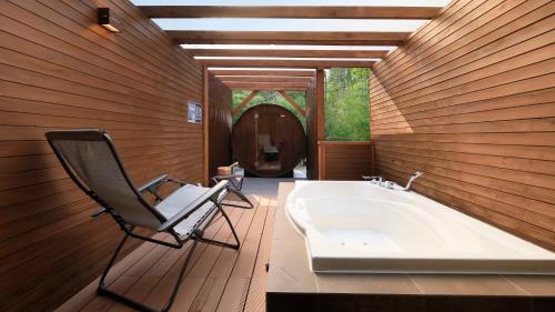 a bathroom with a chair next to a bath tub at Hakone Fuga - Adult Only in Hakone