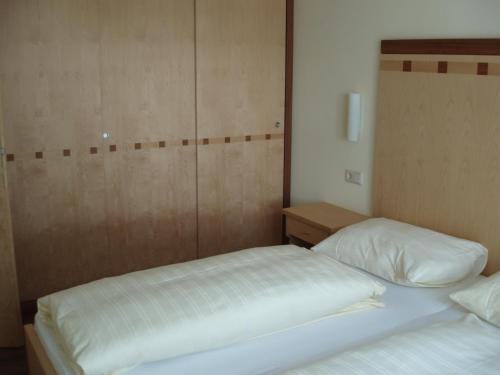 a bedroom with two beds and a wooden wall at smartFLATS in Dorfgastein
