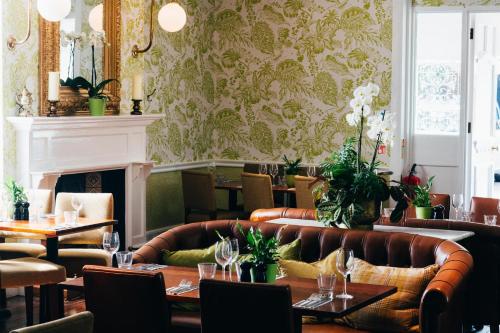 a restaurant with couches and tables and a fireplace at Embankment Hotel in Bedford