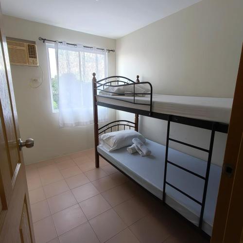 a room with two bunk beds and a window at Rae Condo at Marina Spatial Seaview and Mountain View in Aganan