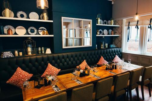 a dining room with a long wooden table and chairs at Embankment Hotel in Bedford