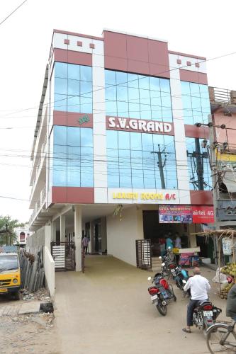 a building with motorcycles parked in front of it at SV Grand in Proddatūr