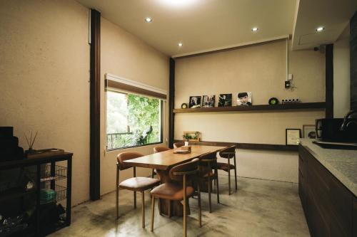 una cocina con mesa y sillas y una ventana en Nancheng Renlan, en Anping