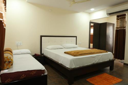 a bedroom with two beds with white sheets at SV Grand in Proddatūr