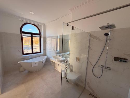 ゲーラにあるPromenaden Hotelの浴槽、洗面台、シャワーを備えたバスルーム