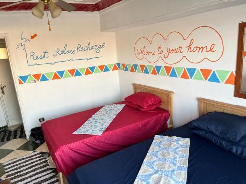 a bedroom with two beds and a sign on the wall at Aisha guesthouse in Aswan