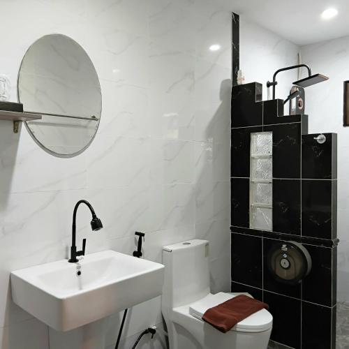 a bathroom with a sink and a toilet and a mirror at Homestay Chiangrai in Chiang Rai