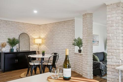 a living room with a table and a bottle of wine at Seaview Escape Ocean Views & 500MBs Wifi in Perth