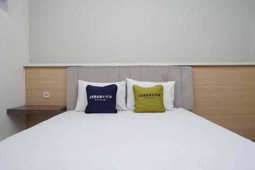 a bed with two pillows on top of it at Urbanview Hotel Double Tree near RSUD Margono Purwokerto in Purwokerto