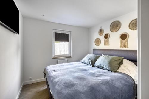 1 dormitorio con 1 cama y algunos platos en la pared en Cosy Nest, en Noordwijk aan Zee