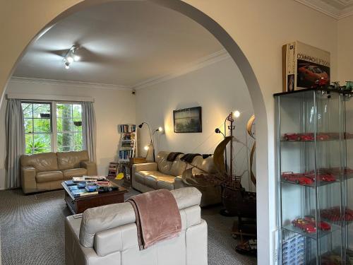 an archway in a living room with a couch and a table at Palm Beach Bed & Breakfast in Palm Beach