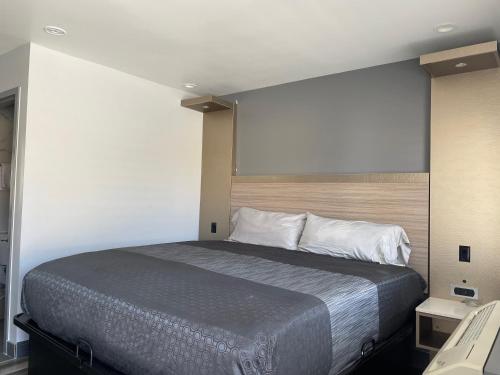 Una cama o camas en una habitación de Bronco Motel South Central