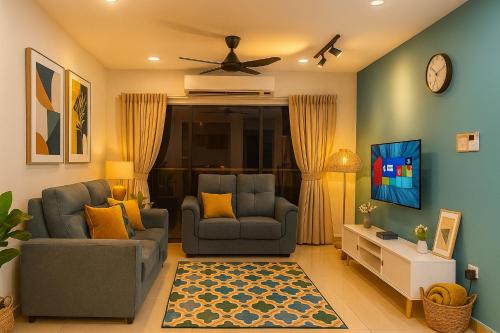 a living room with two chairs and a tv at Cozy homestay Manhattan Ipoh,12 pax 怡保民宿 in Ipoh