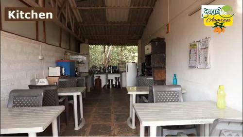 a restaurant with tables and chairs in a room at Devraai Homestay 