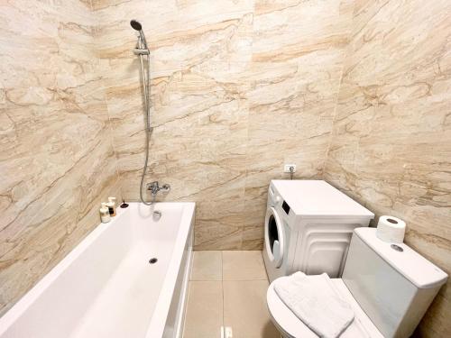 een badkamer met een wit toilet en een bad bij Central Address Studio 16 in Boekarest