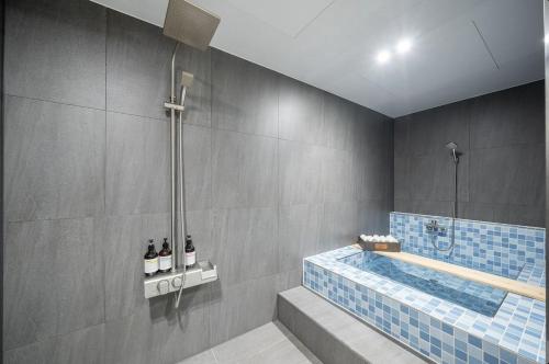 een badkamer met een bad en een douche bij Jeonju Summit Stay in Jeonju