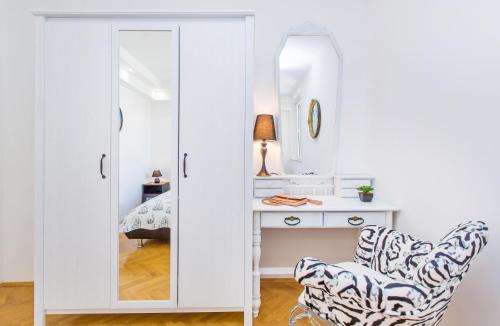 um quarto com um espelho e uma secretária com uma cadeira em Apartment Majestic em Dubrovnik