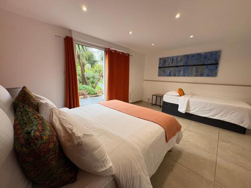 a bedroom with two beds and a window at Au Petit Bignon in Les Épesses