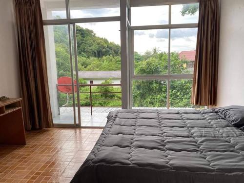 een slaapkamer met een bed en een groot raam bij our home at lanta in Koh Lanta