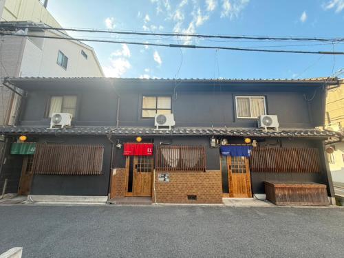 a building with doors and windows on a street at TSUDOYA Tsuruhashi 集家鶴橋 in Osaka