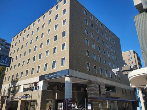 a tall building on a city street at KOKO HOTEL Shizuoka - formerly Hotel Wing International Shizuoka in Shizuoka