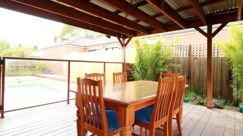 a wooden table and chairs on a deck at Sweet Home at Carrum Downs in Carrum Downs