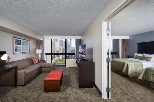 a hotel room with a bed and a couch at Staybridge Suites Atlanta - Midtown by IHG in Atlanta